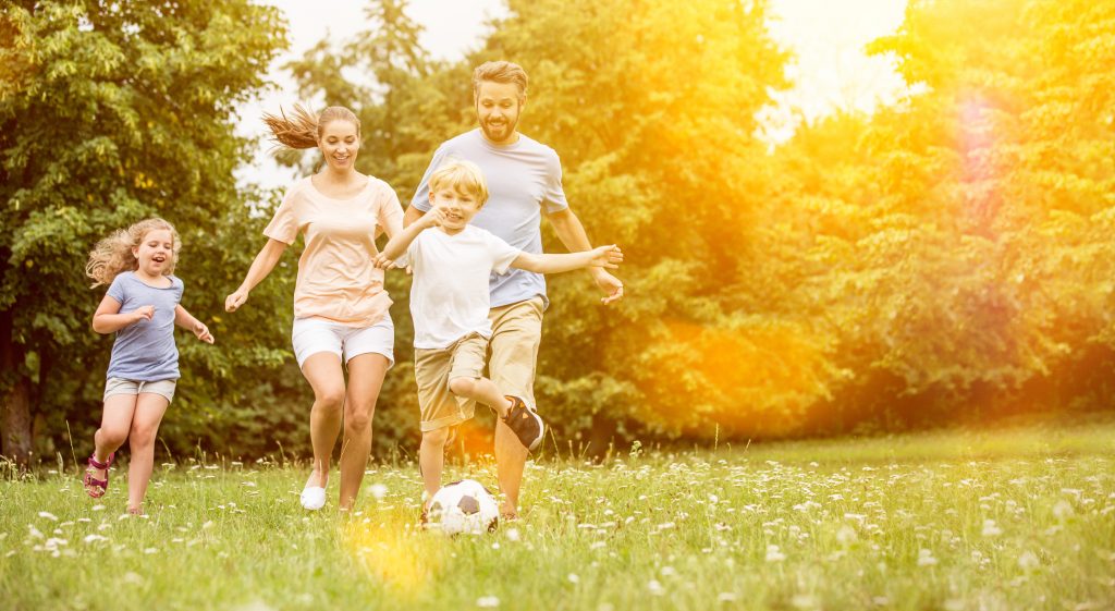 Familie spielt Fußball im Garten